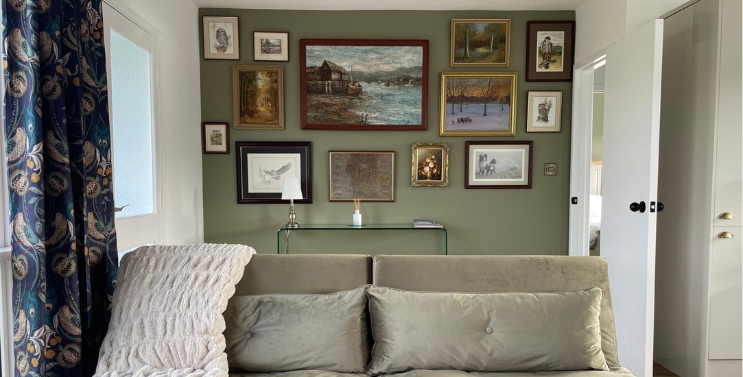 The cosy living room, with a collected gallery wall and a comfortable sofa