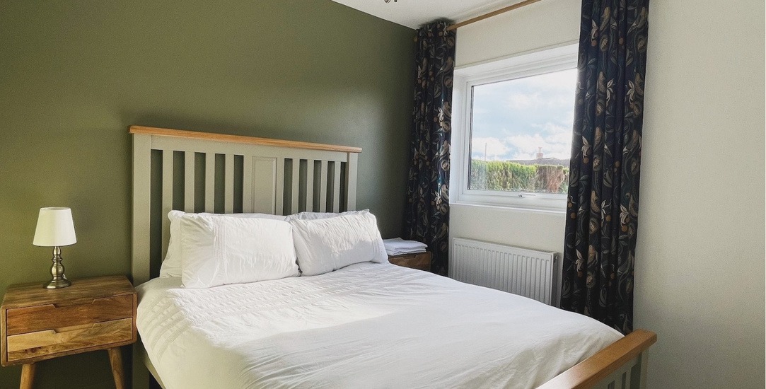 The double bedroom with soft linens and warm natural furnishings